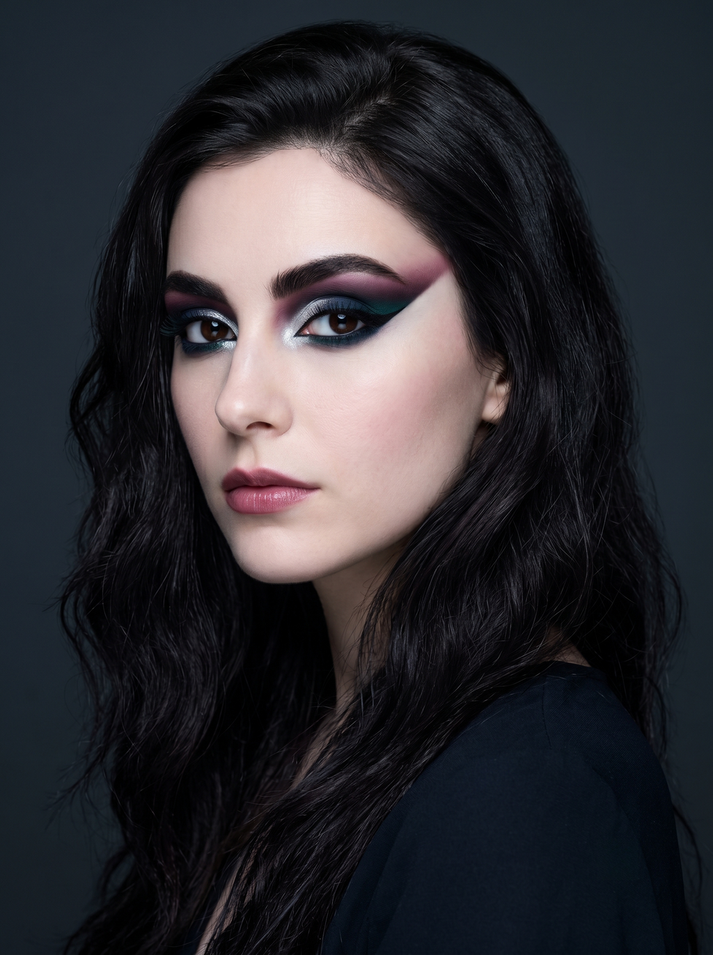 Diepe Winter festivaloog met een lange grafische wing die verloopt van bes bij de wenkbrauw via marineblauw door de crease naar teal bij de wimperlijn, over een chroomzilveren ooglid met een zwarte tightline