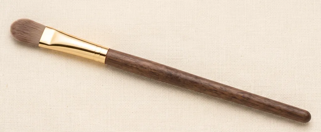 Small, flat tapered concealer brush for precise under-eye and blemish coverage